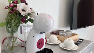 A kitchen area with a white appliance, a vase with flowers, and a tray with dishes.