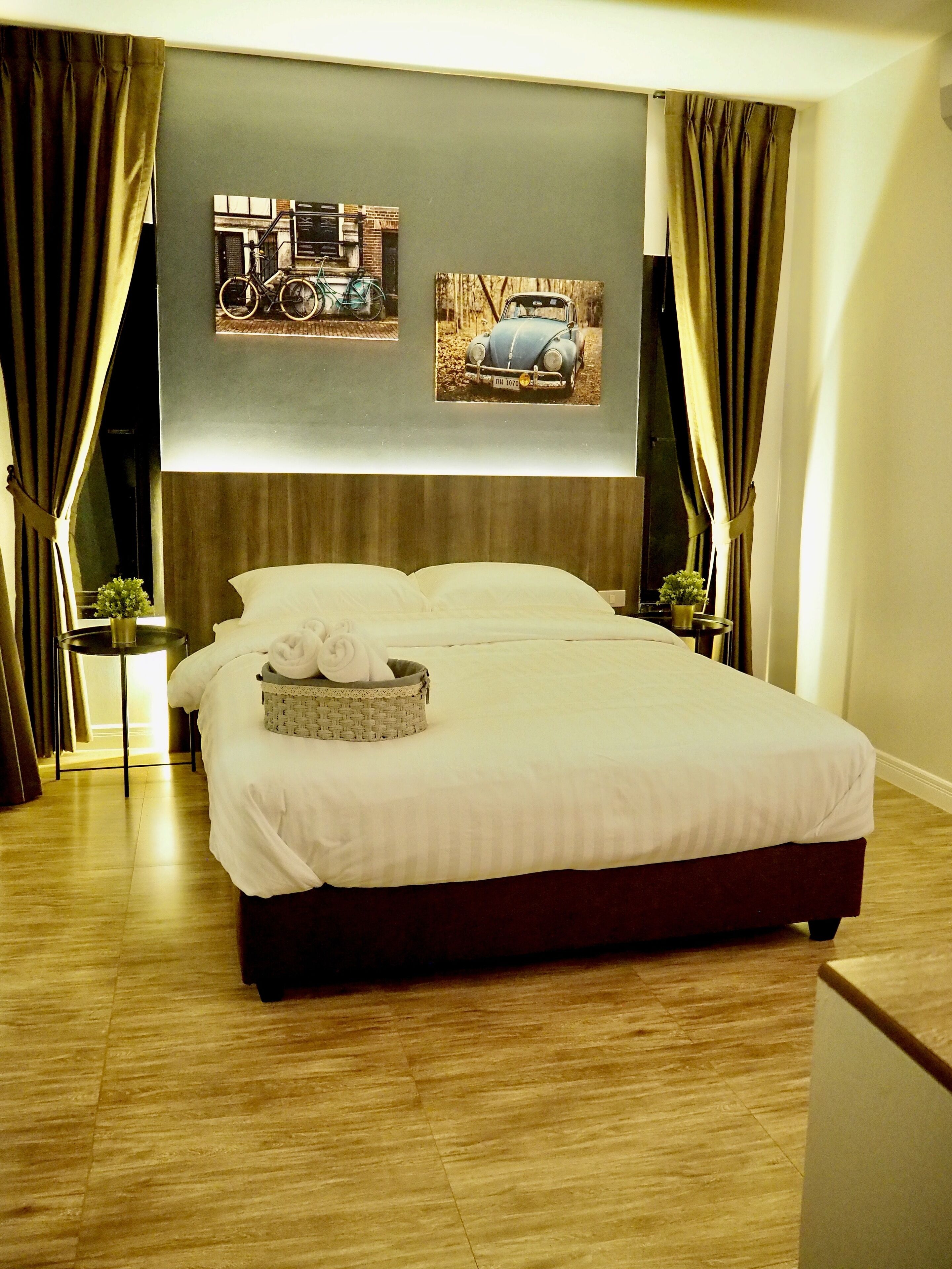 A hotel room with a large bed, two nightstands, a wall-mounted TV, and a window with curtains.