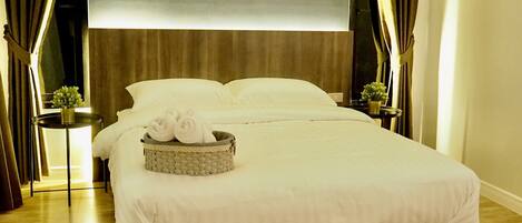 A hotel room with a large bed, two nightstands, a wall-mounted TV, and a window with curtains.