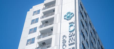 Un edificio de hotel alto con varios balcones y cielo despejado.