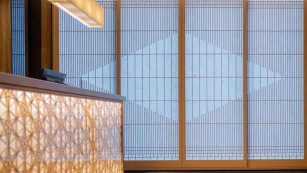 A reception area with a patterned wall and a reception desk.