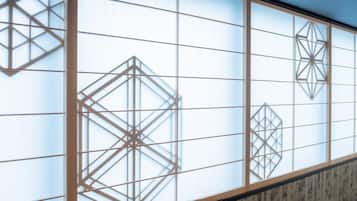 A room with a large window featuring geometric patterns.