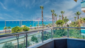 A balcony with a view of the sea, palm trees, and a sign for the Blue Lagoon Hotel. - Arsi Paradise Beach Hotel (Alanya)