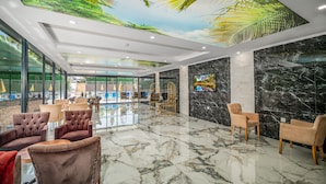 A spacious lobby with a high ceiling, marble flooring, and comfortable seating areas. - Arsi Paradise Beach Hotel (Alanya)