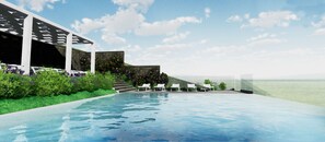 Een seizoensgebonden buitenzwembad en ligstoelen