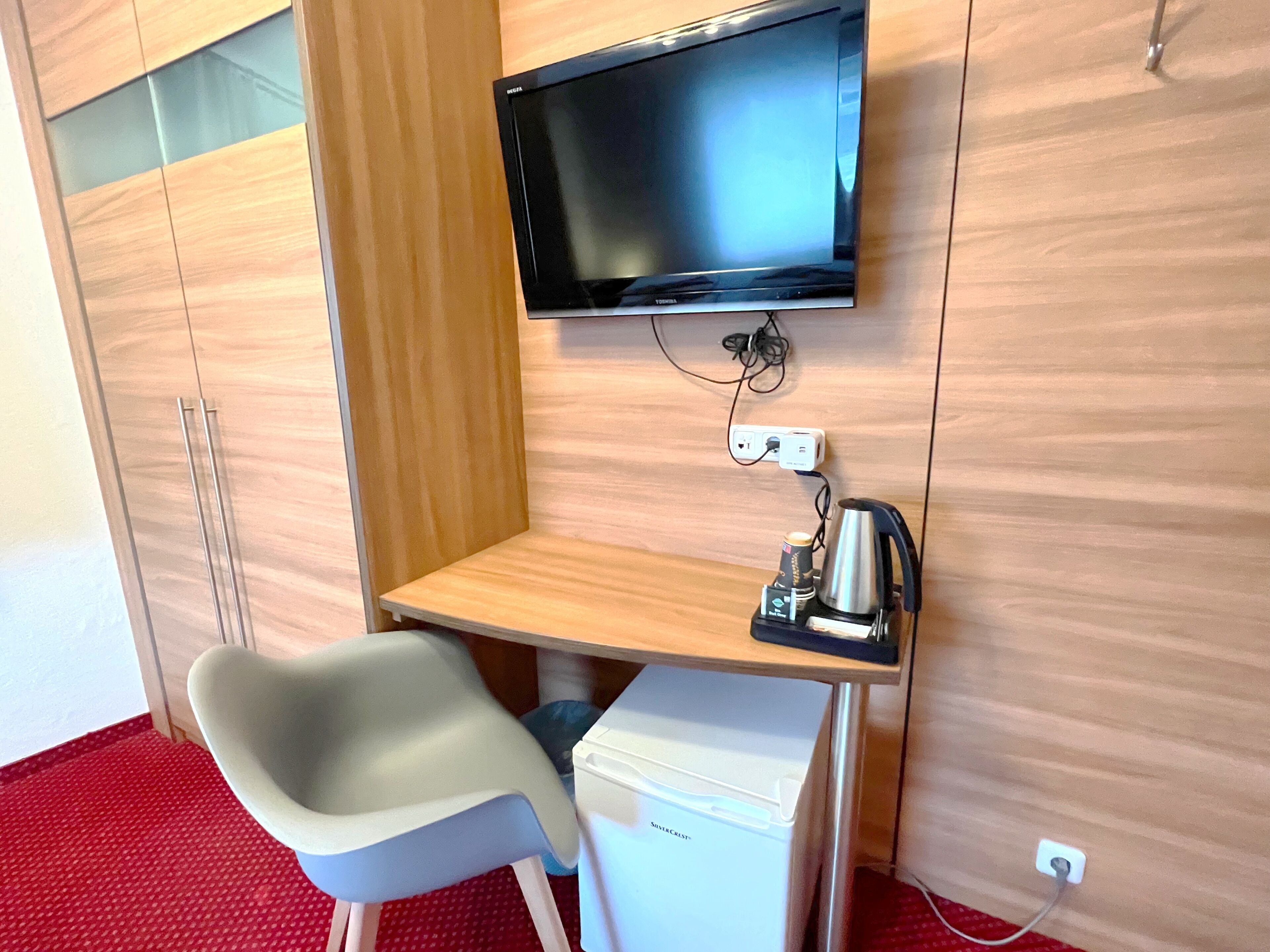 A small workspace with a desk, chair, and a coffee machine.