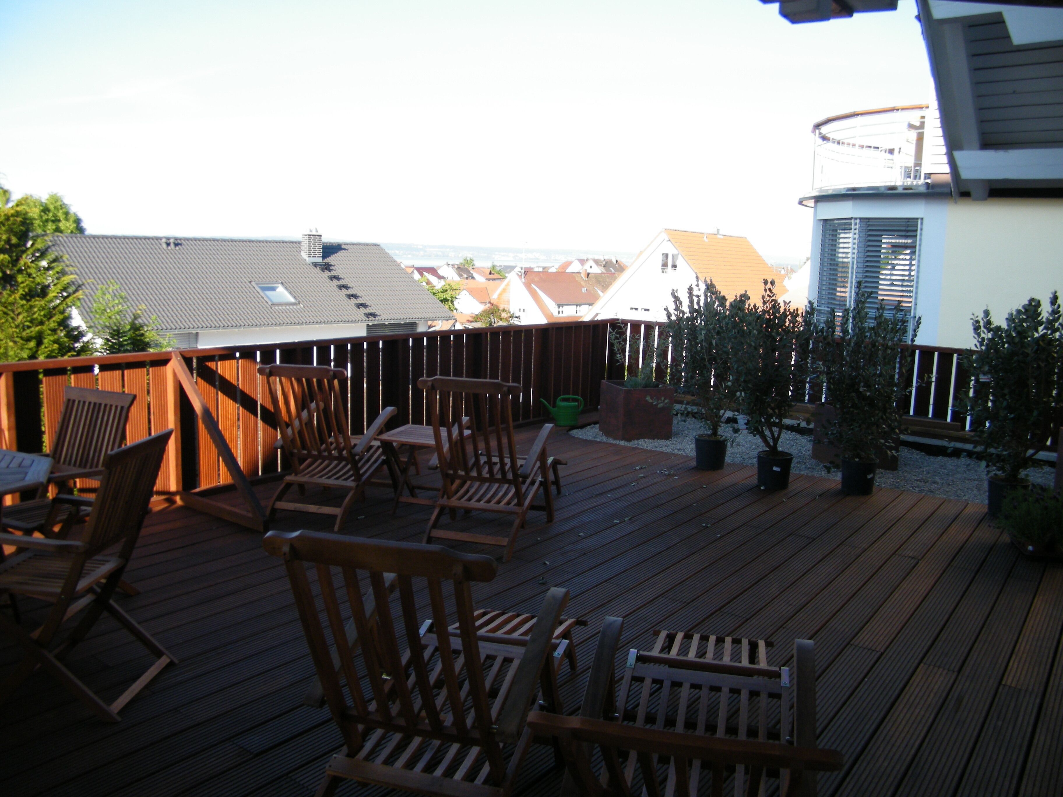 A wooden deck with outdoor furniture and potted plants.
