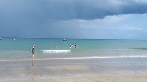 Een strand met heldere lucht en rustig water.