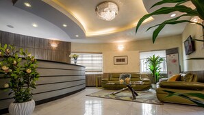 Eine moderne Lobby mit einer Rezeption, Sofas und Zimmerpflanzen.