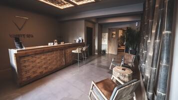 A reception area with a wooden reception desk, a waiting area with chairs, and a reception desk with a sign that reads "VANITY SPA".