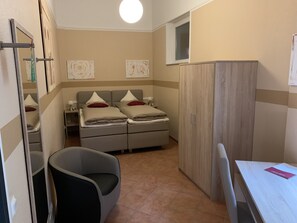 A small, well-lit room with a bed, a desk, and a wardrobe. - Hotel Stegmann's HOF (Sehnde)