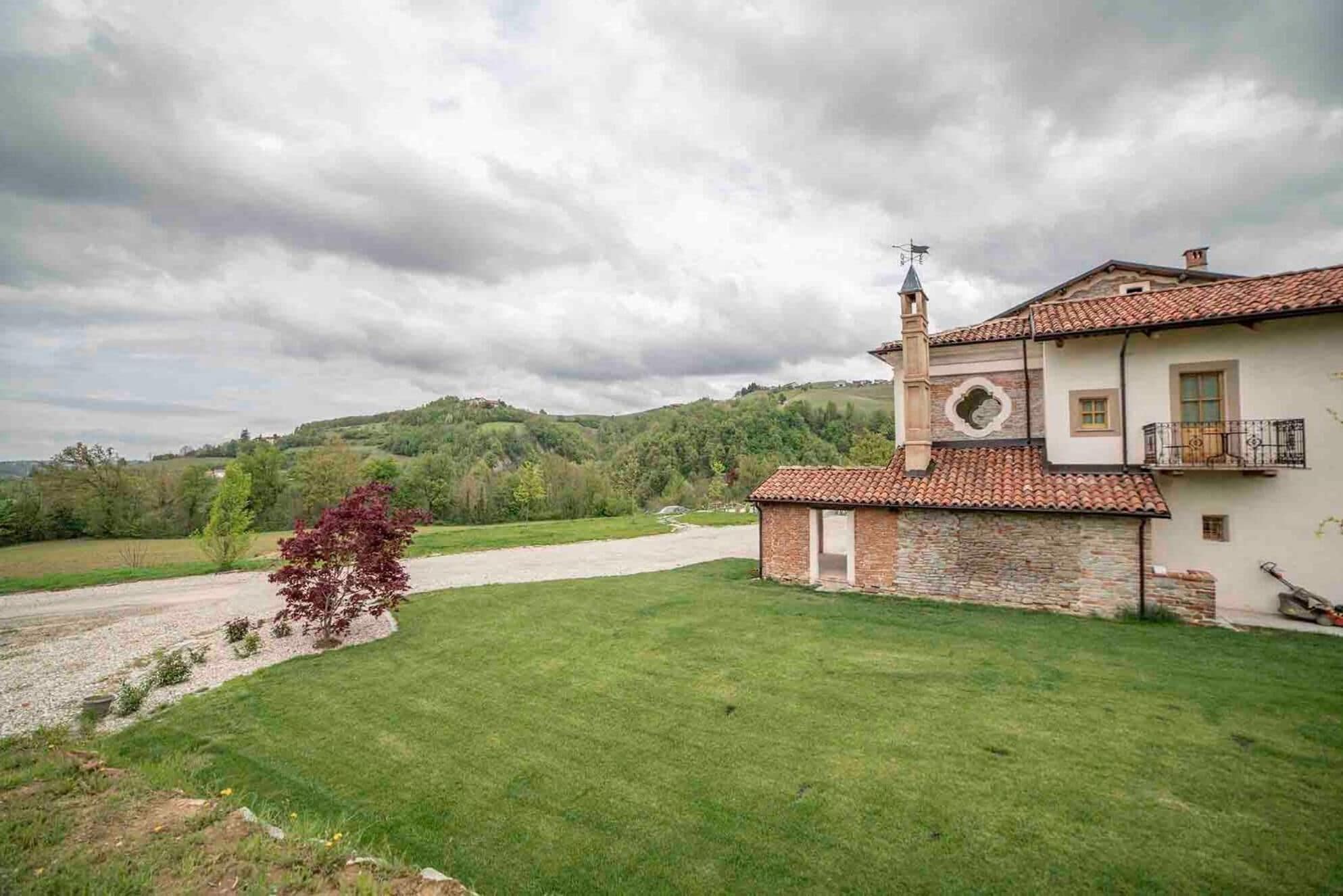 Une maison à deux étages avec une façade en pierre, un toit en tuiles et un petit balcon.