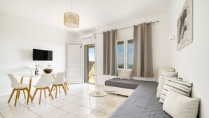 Un salon moderne et bien éclairé, avec un canapé, une table à manger et des chaises.