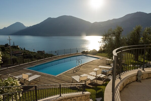 En säsongsöppen utomhuspool och solstolar