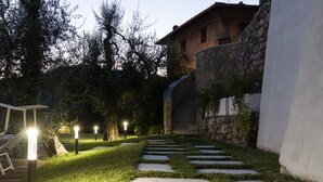 A stone staircase leading to a building with a stone wall and a wooden deck.