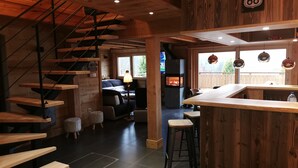 Un intérieur moderne avec un escalier en bois, un coin bar et une cheminée.