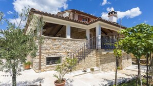 A stone house with a tiled roof, a balcony, and a chimney. - Holiday house Matija with a pool (Svetvincenat)