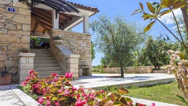 A stone building with a covered entrance and a stone staircase leading to an upper level. - Holiday house Matija with a pool (Svetvincenat)