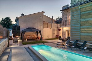Una piscina al aire libre de temporada, sombrillas