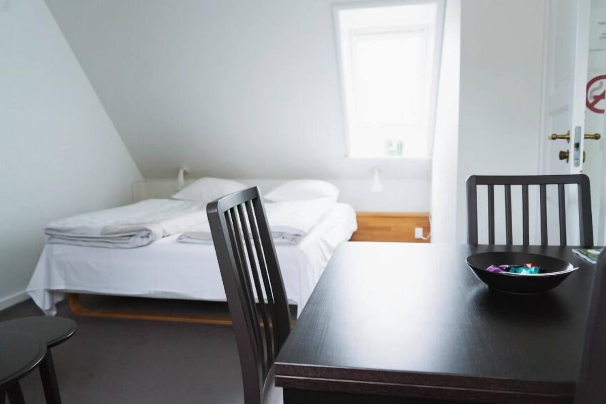 Una habitación con una cama, una mesa y una silla.