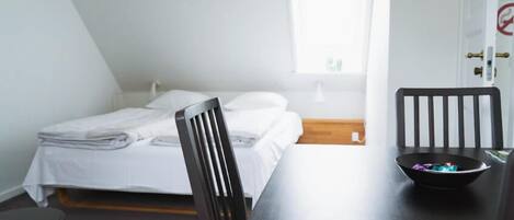A room with a bed, a table, and a chair.
