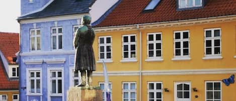 A statue in a courtyard with a building in the background.