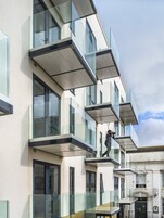 A multi-story building with large windows and a balcony.