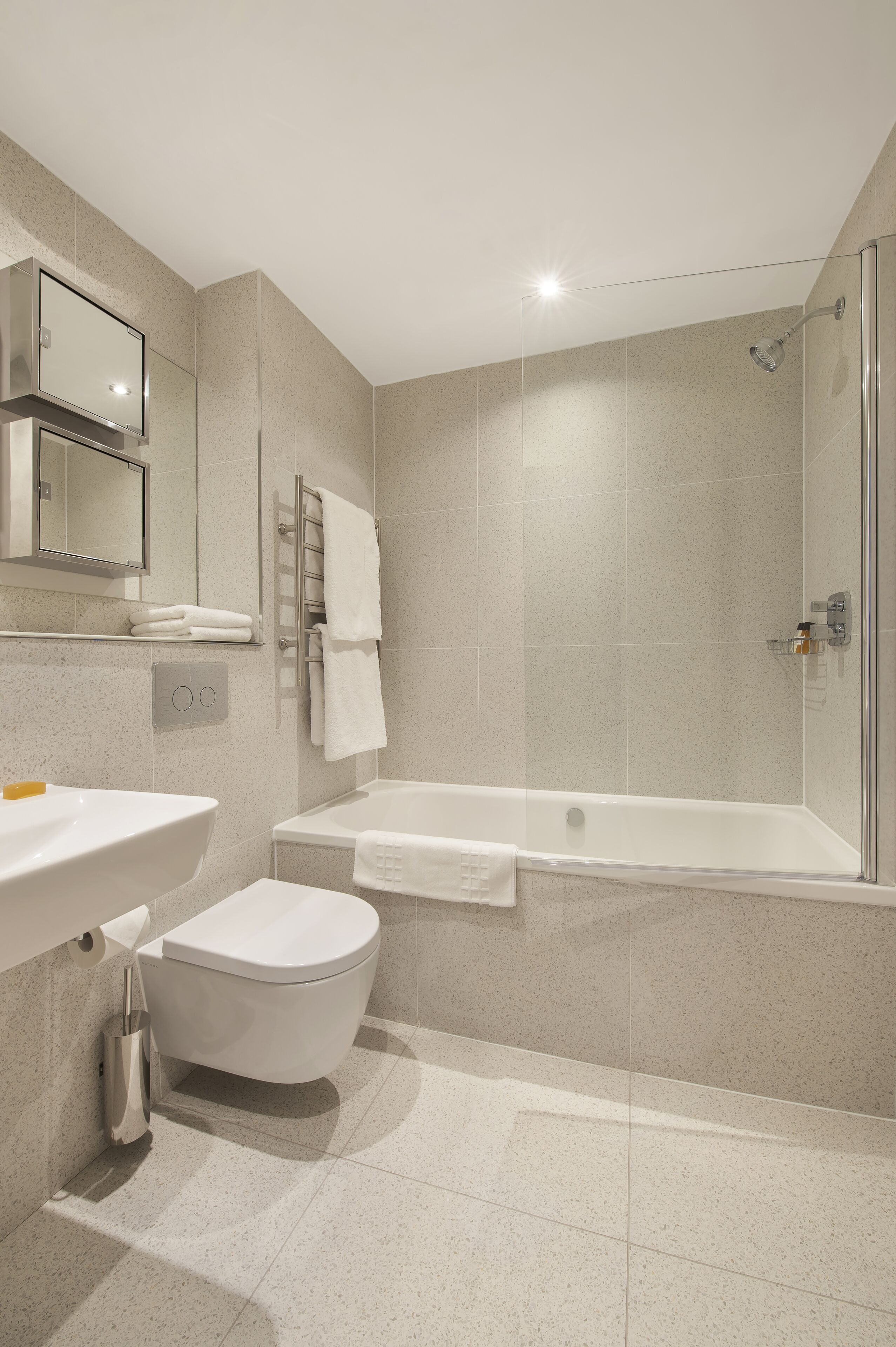 A modern bathroom with a toilet, sink, and bathtub.