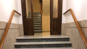 A staircase with marble steps and wooden handrails, leading to an interior space. - Roman Residenza : Bright, Quiet, and Modern in the Center of Rome (Roma)