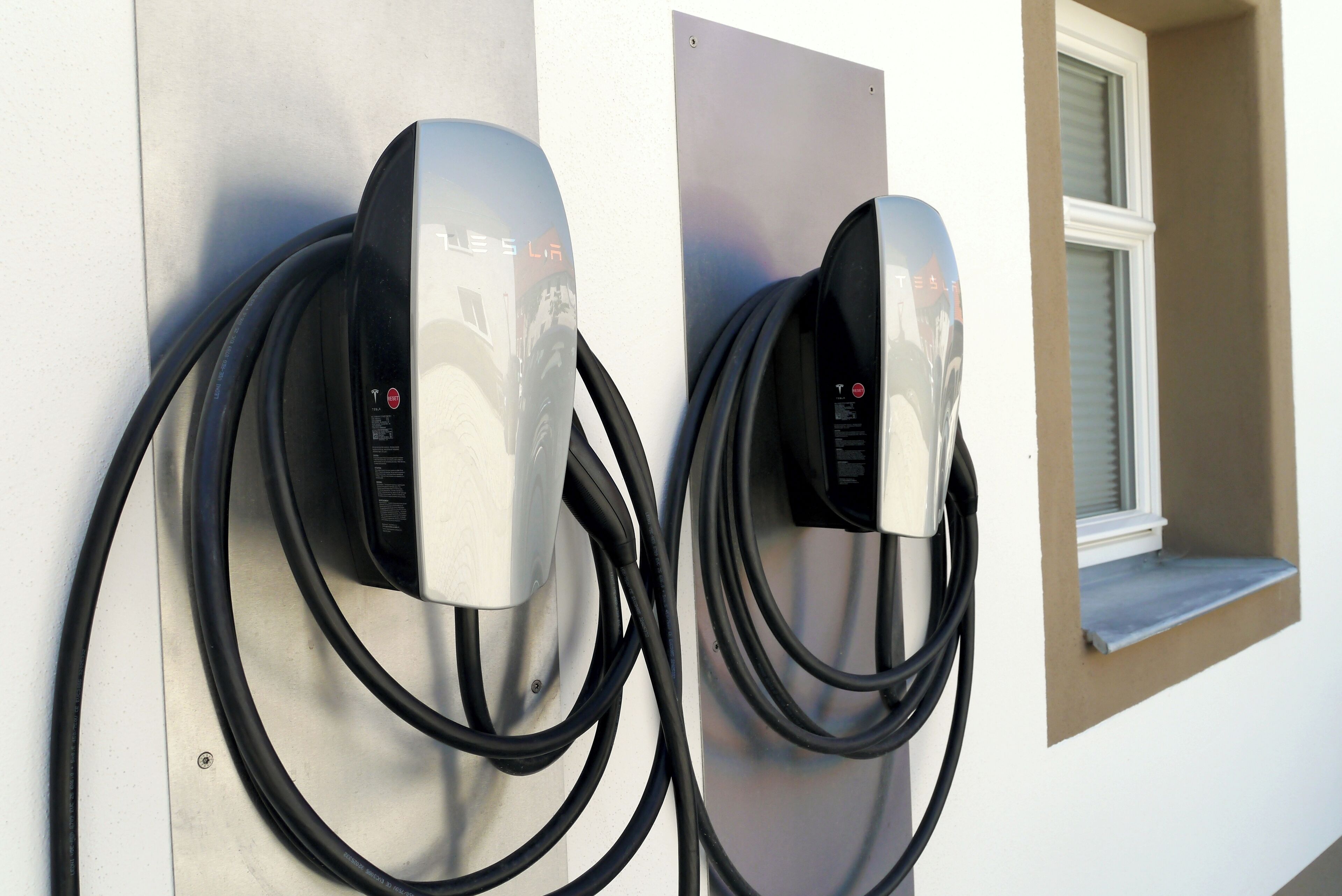 Dos estaciones de carga para vehículos eléctricos instaladas en una pared.
