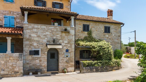 A stone building with a balcony, a door, and a small garden area. - Especially charm stone house with a pool (Marcana)