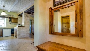 A kitchen with a wooden countertop, a stone pillar, and a tiled floor. - Especially charm stone house with a pool (Marcana)