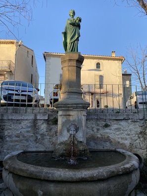 Stunning fountain centerpiece with a statue of a figure holding a child, set amidst a serene backdrop.
