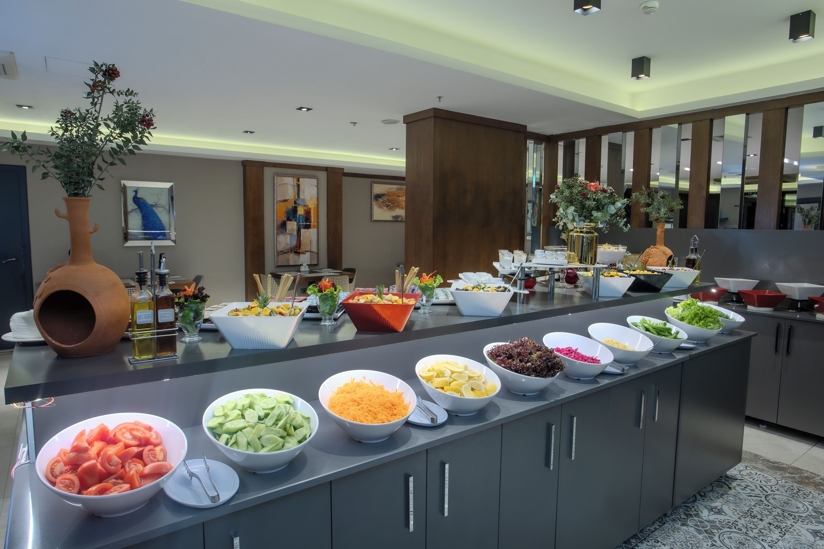 Una mesa de buffet con diferentes tipos de comida y un florero decorativo.
