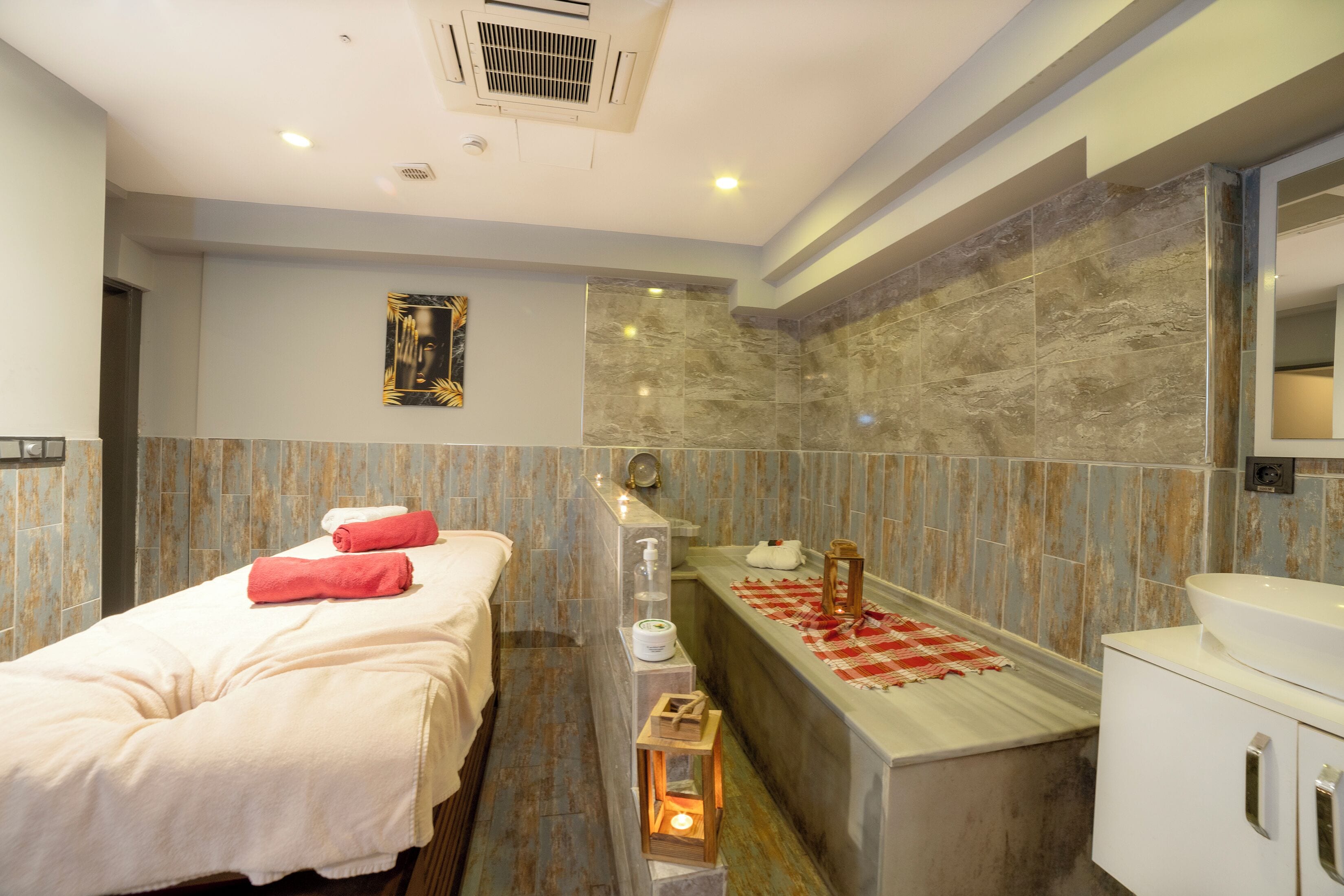 Una habitación de hotel moderna con cama, baño con bañera y espejo.