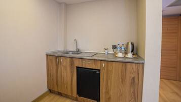 Una cocina compacta con un lavaplatos, armarios de madera y lavavajillas integrado.