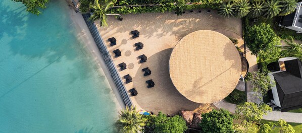 An aerial view of a beach with a circular seating area, a pool, and surrounding greenery. - The Splash Koh Chang (Ko Chang)