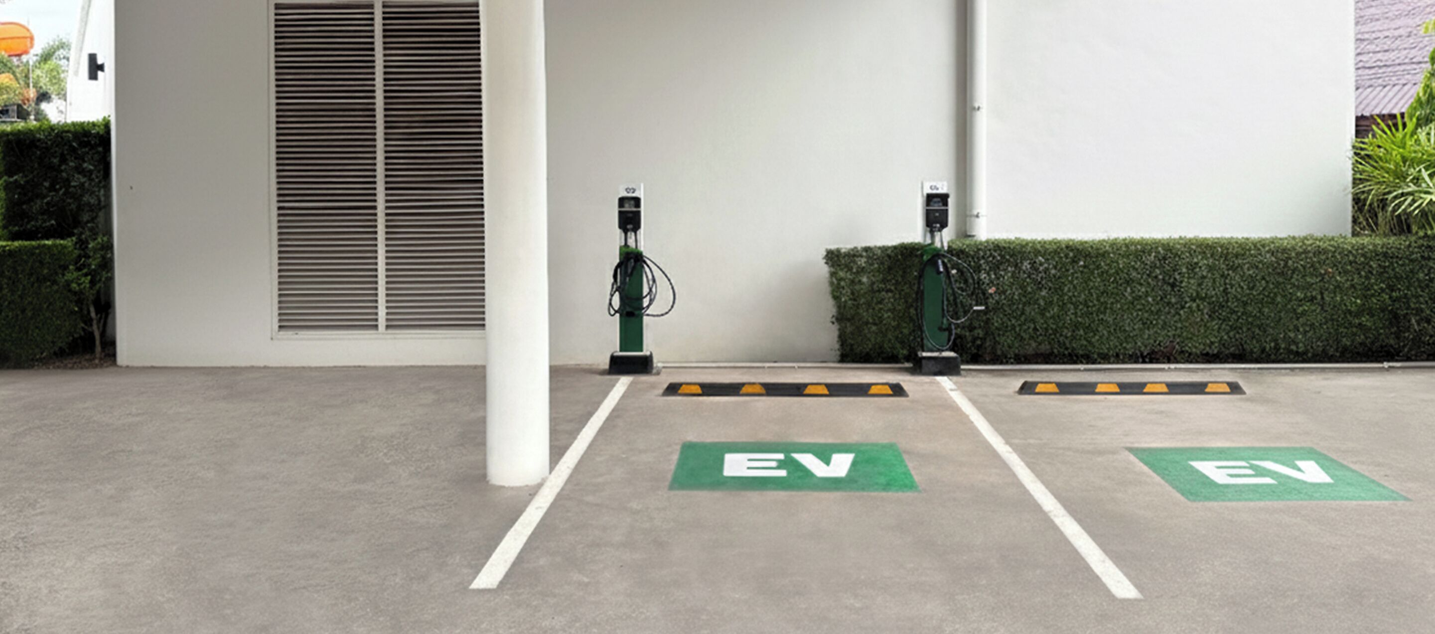 Zona de estaciones de carga para vehículos eléctricos, con dos puntos de carga y espacios de estacionamiento exclusivos para vehículos eléctricos.
