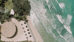 An aerial view of a beach with a circular seating area, a row of beach chairs, and a few palm trees. - The Splash Koh Chang (Ko Chang)
