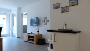 Un salon moderne doté d’un téléviseur à écran plat, de meubles en bois et d’une cheminée.