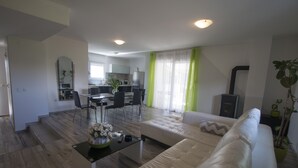 Una sala de estar moderna con un sofá blanco, una mesa de centro y un comedor con sillas y una mesa.