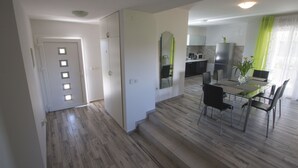 Una cocina moderna con microondas, refrigerador y comedor con sillas y mesa.