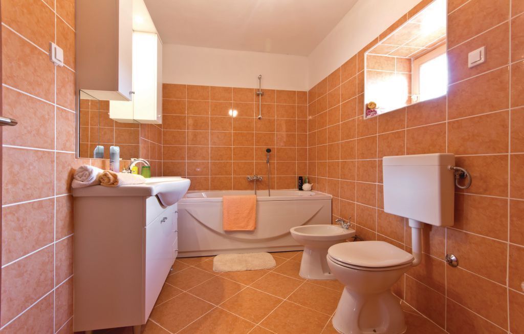 A bathroom with a bathtub, toilet, and sink.