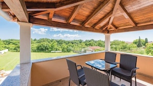 A covered outdoor area with a table and chairs, overlooking a green landscape. - Lovely Villa Ana (Svetvincenat)