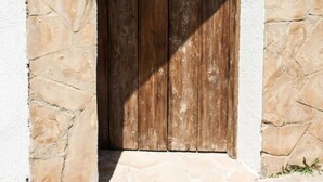 A rustic wooden door with a sign that reads "Casa Caprice" above it, set in a stone wall with a number "22.4" visible on the right. - Private villa with fantastic sea view! (Lloret de Mar)
