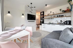 A modern kitchen with white cabinets, a black countertop, and a coffee machine. - RentPlanet - Apartamenty Izerska (Szklarska Poreba)