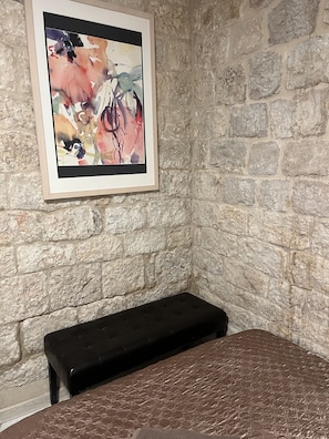 Relax in this cozy corner room featuring a comfortable bed and a unique abstract art piece.