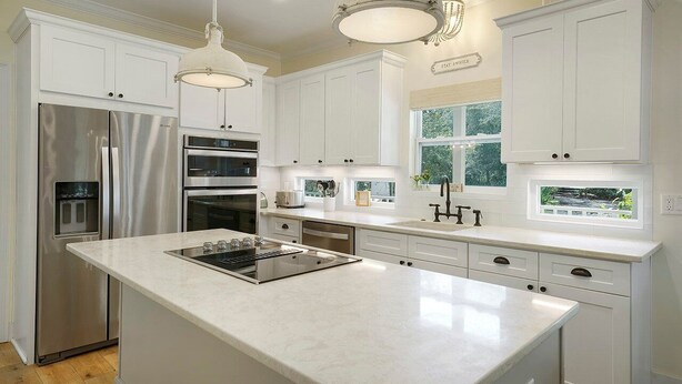 A modern kitchen with white cabinetry, stainless steel appliances, and a central island. - Beach Baby - Secluded Home with Private Pool Area & Deck (Santa Rosa Beach)