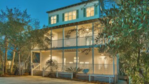 A two-story house with a balcony and a covered porch. - Beach Baby - Secluded Home with Private Pool Area & Deck (Santa Rosa Beach)