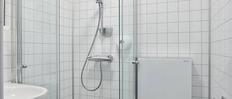 Une salle de bain moderne avec une douche à parois de verre, des toilettes blanches et un lavabo.